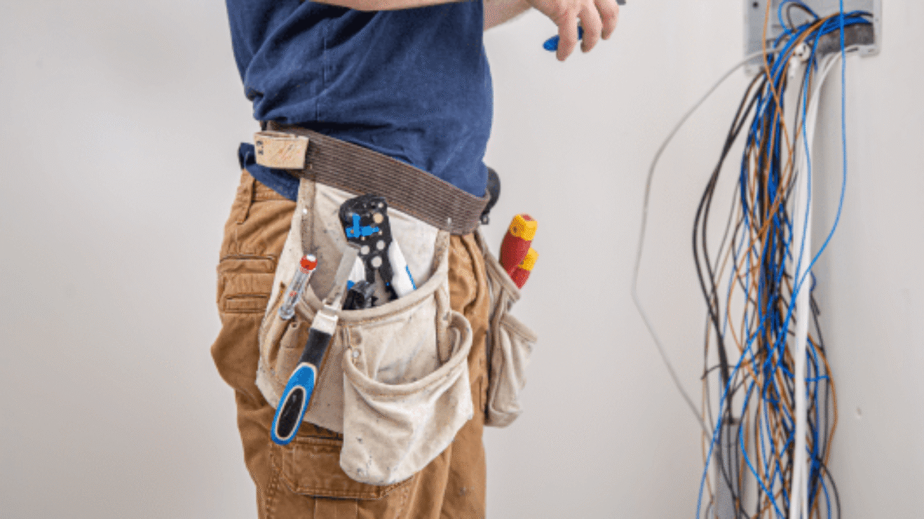 electrician-builder-work-examines-cable-connection-electrical-line-fuselage-industrial-switchboard-professional-overalls-with-electrician-s-tool 1-min