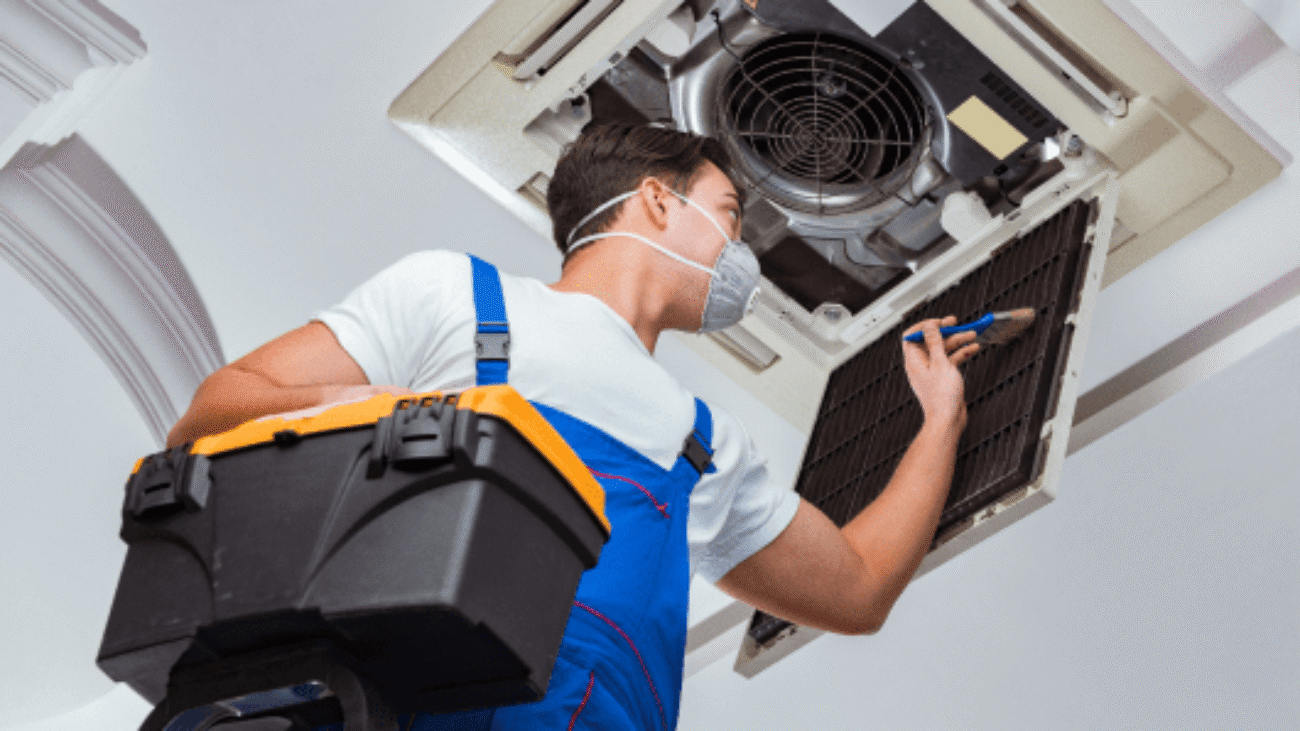 worker-repairing-ceiling-air-conditioning-unit 1-min